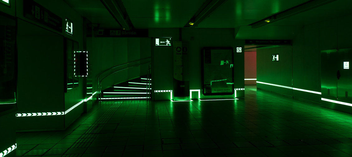Showcase of multiple glow in the dark signs, tape and arrows in a subway station