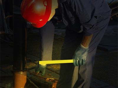 man working on a boat with chemical light in hand