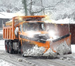 Orange snow plow in action with LED rectangular headlight