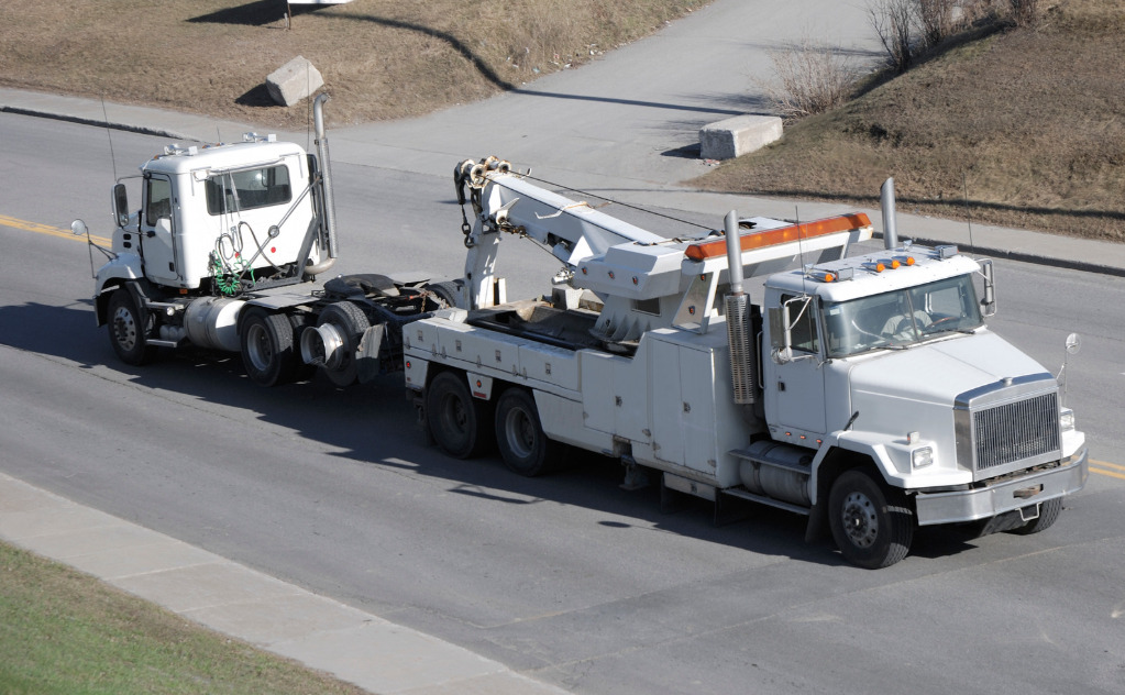 Towing truck towing a truck with lights on
