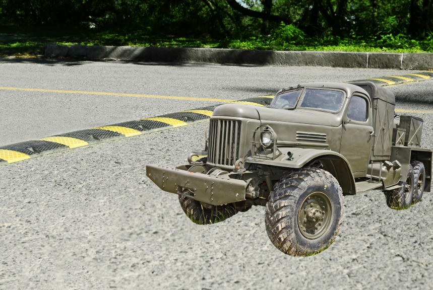 A military vehicle next to a speed bump