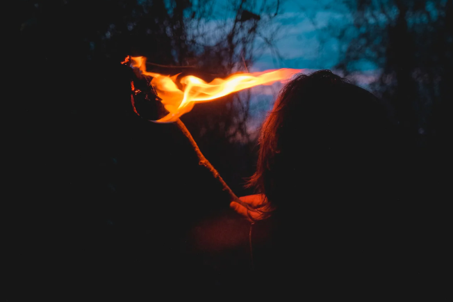 A person holding a torch in the dark